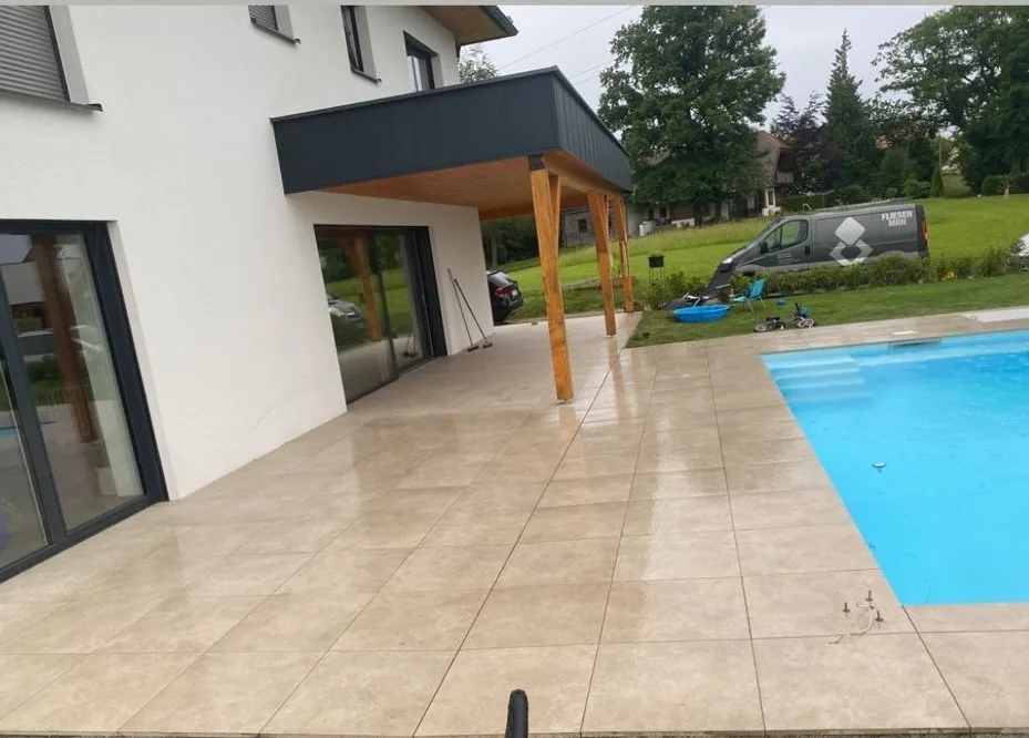 Terrasse am Haus mit hellen Platten und Pool