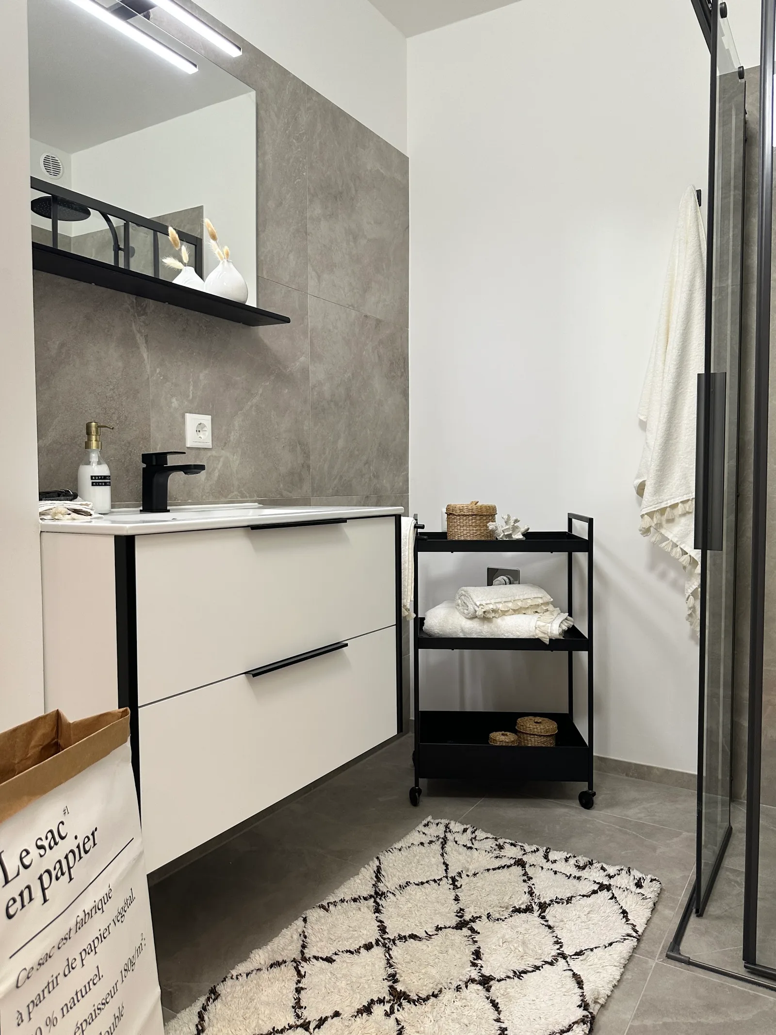 Fertiges Bad mit grauen Großformatplatten an der Wand