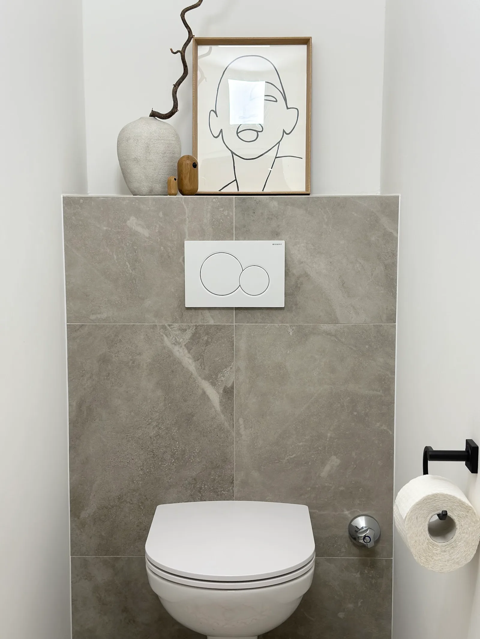 WC-Vorwand mit grauen Fliesen in Marmoroptik